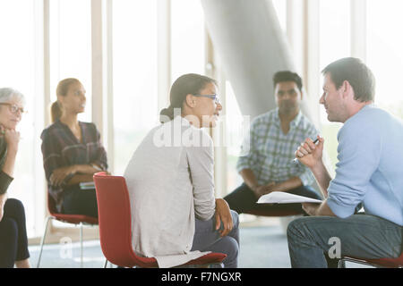 Geschäftsleute, die Papiere in Treffen diskutieren Stockfoto