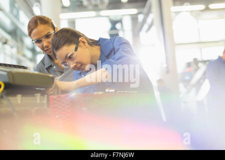 Weibliche Mechanik arbeiten am Motor in Auto-Werkstatt Stockfoto