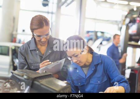 Weibliche Mechanik arbeiten am Motor in Auto-Werkstatt Stockfoto