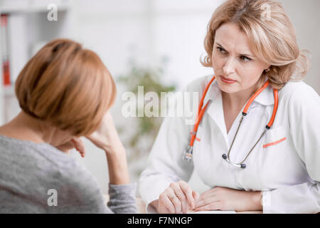 Ernst Arzt oder Arzt verärgert Patienten betrachten Stockfoto