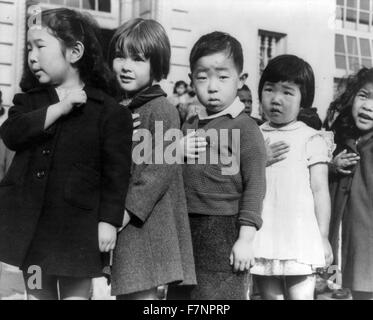 San Francisco, Kalifornien, April 1942. Erstklässler, einige japanische Abstammung an der Weill Public School Verpfändung Treue zur Flagge Vereinigten Staaten. Die evakuierten japanischer Abstammung werden im Krieg Umzug Behörde Zentren für die Dauer des Krieges untergebracht werden Stockfoto