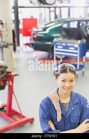 Porträt zuversichtlich Mechaniker mit verschränkten in Autowerkstatt Stockfoto