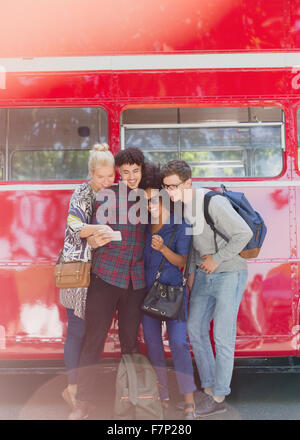 Freunde nehmen Selfie neben Doppeldecker-bus Stockfoto