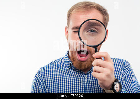 Porträt von legerer Mann Blick durch die Lupe in die Kamera auf einem weißen Hintergrund isoliert Stockfoto