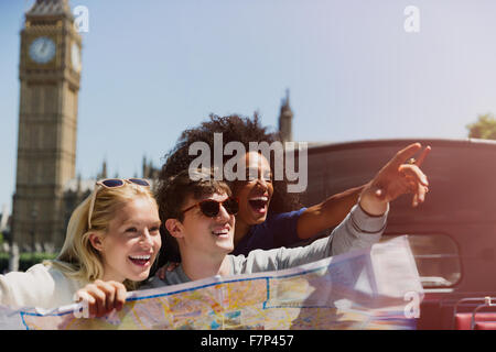 Begeisterte Freunde mit Karte unten Glockenturm Big Ben in London Stockfoto