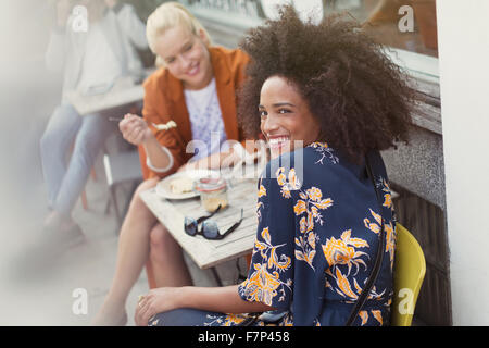 Porträt lächelnde Frau mit Freund im Straßencafé Stockfoto