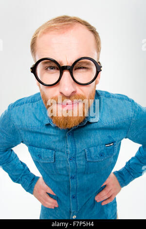 Wütend amüsant junger Mann mit Bart in lustiger Runde Brille über Whire Hintergrund isoliert Stockfoto