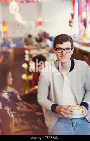 Porträt, Lächeln Mann mit Brille trinken Cappuccino im café Stockfoto