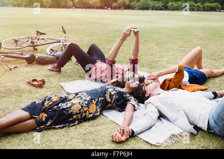 Freunde, relaxen und Selfie in Kreis auf Decke im park Stockfoto