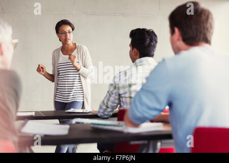 Lehrer im Gespräch mit Studenten in Erwachsenenbildung Klassenzimmer Stockfoto