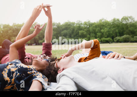 Freunde nehmen Selfie Verlegung im Kreis im Rasen Stockfoto