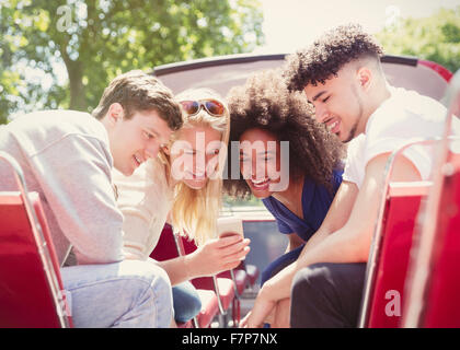 Freunde SMS mit Handy auf Doppeldecker-bus Stockfoto