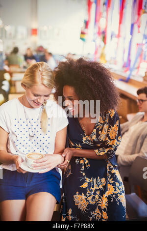 Freunde, lachen und trinken Cappuccino im café Stockfoto