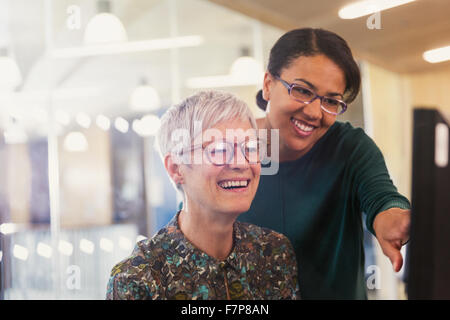 Lächelnde Unternehmerinnen am Computer im Büro Stockfoto