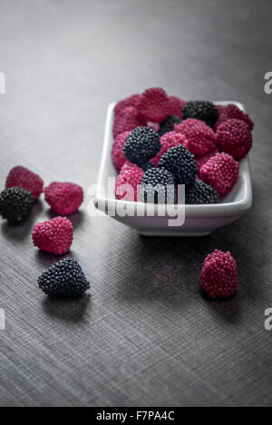 bunte Jelly Bonbons in Schüssel auf Holztisch, Nahaufnahme Stockfoto