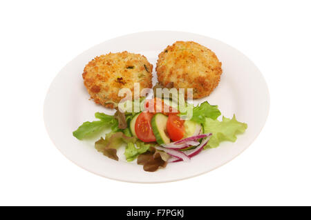 Fischfrikadellen und Salat auf einem Teller isoliert gegen weiß Stockfoto