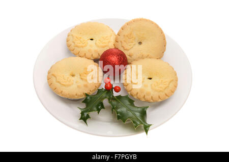 Holly geschmückt Mince Pies mit einer Weihnachtskugel und einen Zweig der Stechpalme auf einem Teller isoliert gegen weiß Stockfoto