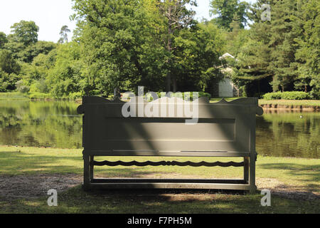 Eine Bank mit Blick auf den See im Claremont Landschaftsgarten, Surrey. Stockfoto