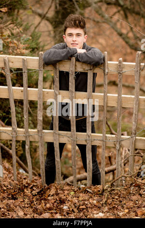 Teenager an einen Zaun gelehnt Stockfoto