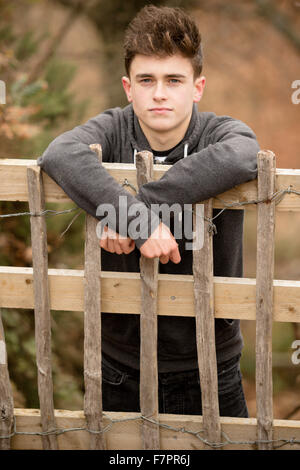 Teenager an einen Zaun gelehnt Stockfoto