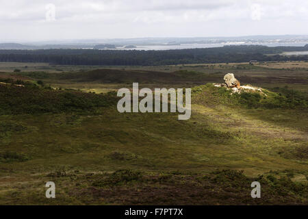 Blick auf die Agglestone am Godlingston Heath, Dorset, Teil der Purbeck-Landschaft. Reiter können in der Ferne gesehen werden. Die Agglestone steht ein 400 Tonnen Eisenstein Felsen auf Godlingston Heath. Es gibt mehr als 54 Meilen von Wanderwegen und Reitwegen Stockfoto