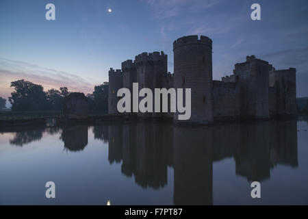 Bodiam Castle, East Sussex, spiegelt sich in den Graben kurz vor der Morgendämmerung. Stockfoto