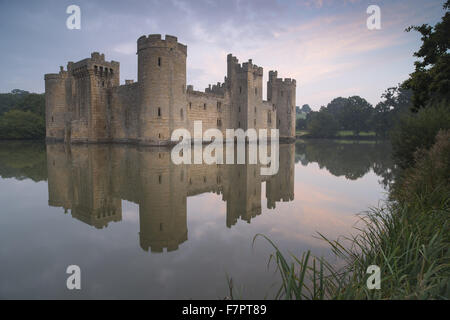 Bodiam Castle, East Sussex, spiegelt sich in den Graben in der Morgendämmerung. Stockfoto