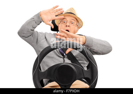 Angst senior Mann sitzt auf einem Kindersitz mit Sicherheitsgurt befestigt und Gestikulieren mit den Händen isoliert auf weißem Hintergrund Stockfoto
