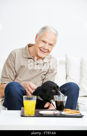 Happy senior woman streichelt seinen Hund zu Hause Stockfoto
