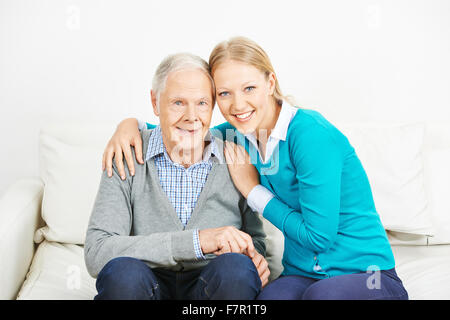 Glückliche Mädchen umarmen senior Greis Stockfoto