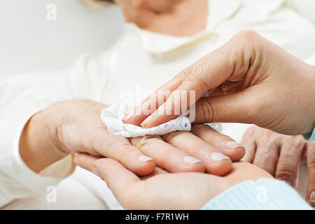 Hände, die helfen bei der Körperpflege für ältere Frau Stockfoto