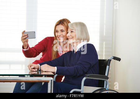 Tochter und senior Mutter nehmen Selfie mit einem smartphone Stockfoto