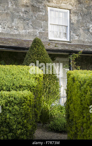 Südseite des Hauses, mit Veranda, Buchsbaumhecken und abgeschnittene Eiben Hecke bei Plas Yn Rhiw, Gwynedd. Die Gärten von Plas Yn Rhiw haben spektakuläre Ausblicke über Cardigan Bay. Stockfoto