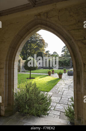 Blick auf den Vorplatz Garten bei Nymans, West Sussex, gesehen durch den Torbogen des Hauses Gartensaal Veranda, im Oktober. Stockfoto