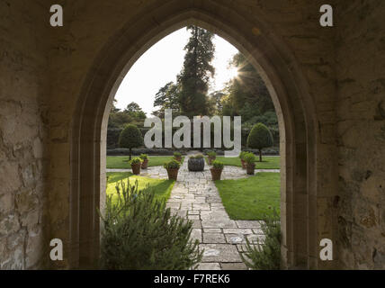 Blick auf den Vorplatz Garten bei Nymans, West Sussex, gesehen durch den Torbogen des Hauses Gartensaal Veranda, im Oktober. Stockfoto