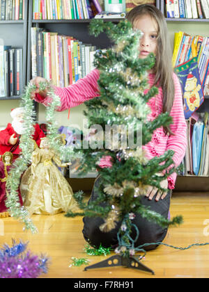 Junges Mädchen Weihnachtsbaum Lametta aufsetzen Stockfoto