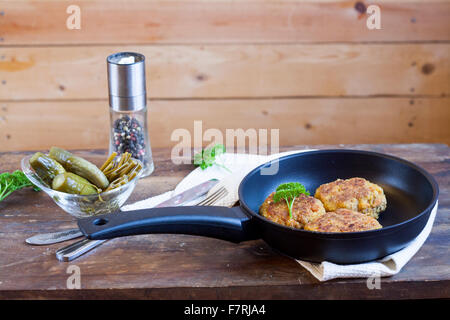 Burger (Schnitzel) In The Frying Pan. Burger (Schnitzel) in der Pfanne auf dem Holztisch Stockfoto