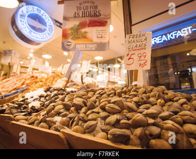 Seattle, Washington, USA. 23. November 2015. Pike Place Market in Seattle begann im Jahr 1907 und wurde entwickelt, um kleine Landwirte und Fischer sowie die Macher von anderen Gütern zu profitieren. Pike Place Market entlang der Waterfront Seattle entlang Elliott Bay gelegen und besteht aus nicht entlang Pike Place, einer Stadtstraße, aber auch mehrere Stockwerke unter sowie. Pike Place Market hat im Laufe der Jahre einige Veränderungen durchgemacht, aber behielt seinen Charme der alten Welt die Touristen aus der ganzen Welt. ---Auf dem Foto verkaufen in einem der mehreren Dutzend Stände, Fisch und andere Meeresfrüchte-Delikatessen, Manila Muschel Stockfoto