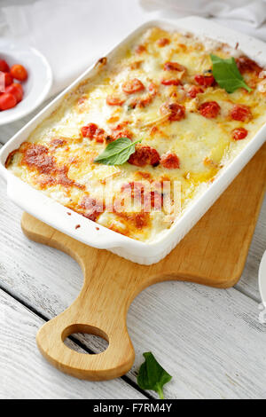 gebackene Lasagne in weiße Schale mit Tomaten Stockfoto