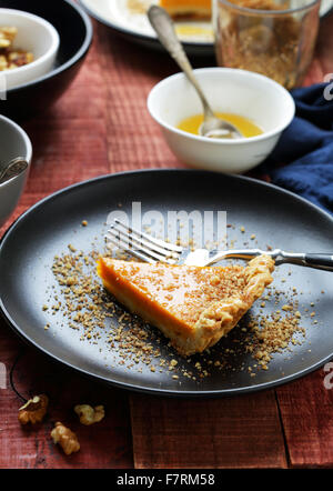 Kürbis-Tarte mit Honig auf Platte Stockfoto