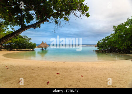 Eine schöne kleine Gezeitenbecken in einer Bucht auf der kleinen französischen Caye mit zwei Tiki Hütten, Roatan, Honduras Stockfoto