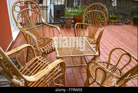 gemütliche Sitzecke auf außen Terrasse, Tisch und Rattan Stühle mit Pflanzkübel Stockfoto