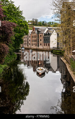 Boote vor Anker auf dem ruhigen Fluss Dart in Totnes zwischen renovierten alten Lagerhäusern auf der einen Seite und grüne Bäume auf der anderen Stockfoto