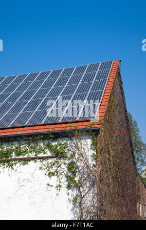Solarzellen auf einer alten Scheune Stockfoto