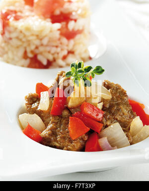 Rindergulasch mit Paprika und Zwiebeln. Serviert mit Reis Stockfoto