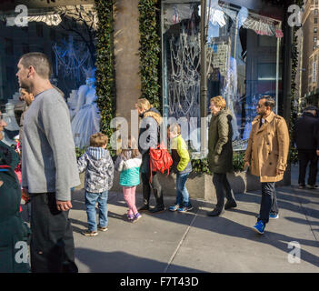 Käufer anzeigen das Weihnachtsfenster von Saks Fifth Avenue in New York auf Sonntag, 29. November 2015, über den schwarzen Freitag Wochenende. Der National Retail Federation berichtete, dass viele Verbraucher aus den Massen entschieden und beschlossen, online einkaufen, obwohl die Menge der Menschen, die Einkaufen in beat Vorhersagen speichert. (© Richard B. Levine) Stockfoto