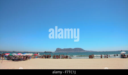 ALGECIRAS, CADIZ, Spanien - 15 AUGUST: Rock of Gibraltar Blick von Algeciras Rinconcillo Strand, voll von Schwimmer. Algeciras, Augu Stockfoto