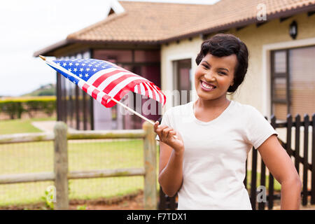 Portrait von hübsche schwarze Frau mit USA-Flagge vor ihrem Haus Stockfoto