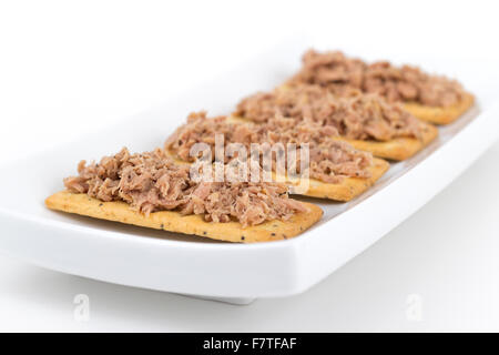 Thunfisch Fleisch auf Cracker als Snack oder Vorspeise auf weißem Hintergrund Stockfoto