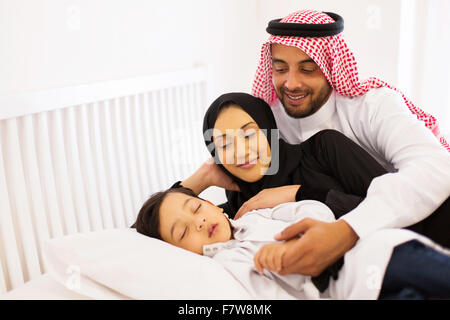 glückliche muslimische Eltern mit ihrem Baby im Bett entspannen Stockfoto